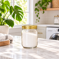 16 oz oxygen bleach refill in a clear glass jar from PurposeFill in Bend, Oregon, styled in a light and clean laundry room.